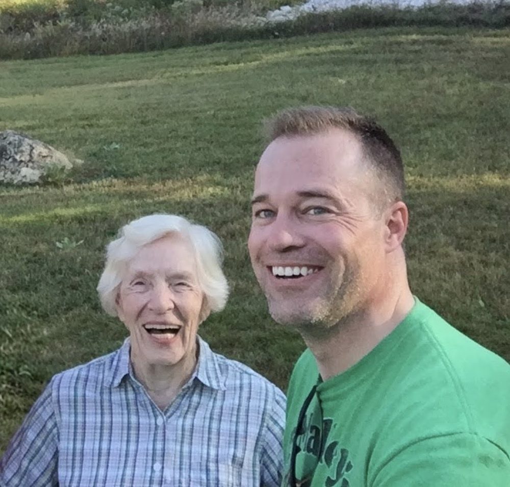 Brian and his grandmother smiling together outdoors
